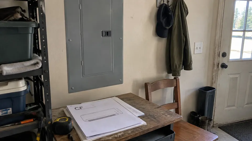 Closed electrical panel beside paperwork for a wall mini split